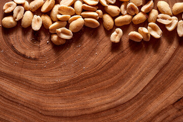 Salted peanuts on a wooden background. With copy space.