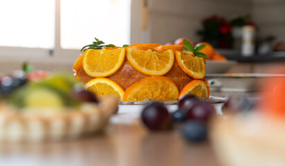 Homemade orange cake with sliced oranges in a kitchen