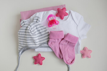 infant baby clothes baby girl pacifier cap on background