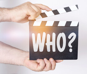 On a white background, a man holds a clapperboard in his hands on which it is written - WHO