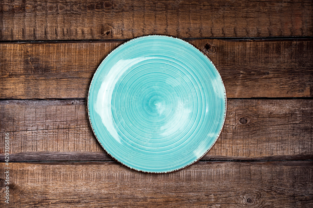 Wall mural empty ceramic blue plate on wood table