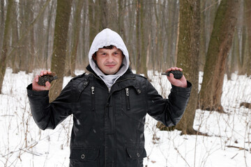 A man with grenade in his hands in the snowy forest