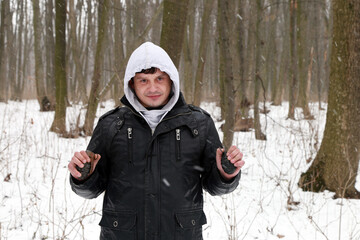 A man with grenade in his hands in the snowy forest
