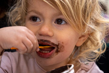 Baby girl eating chocolate icecream