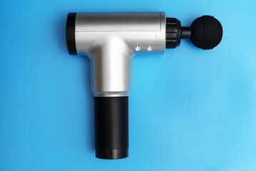 Massage percussion device on blue background.