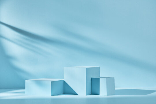 Blue background for product presentation with shadows and light. Empty podiums. Mockup.