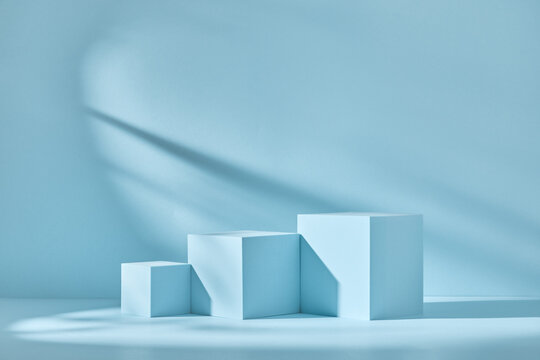 Blue background for product presentation with shadows and light. Empty podiums. Mockup.