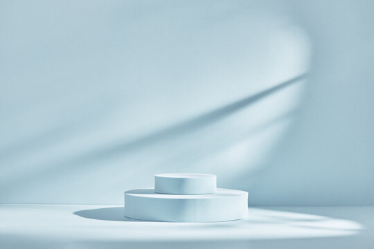 Blue background for product presentation with shadows and light. Empty round podiums. Mockup.