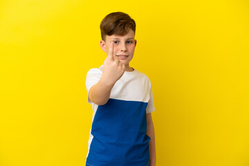 Little redhead boy isolated on yellow background doing coming gesture