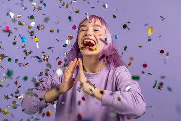 Excited unique woman clapping hands, having fun, screaming WOW, rejoices over confetti rain in...