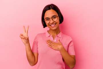 Young mixed race woman isolated on pink background taking an oath, putting hand on chest.