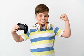 Little redhead boy holding a game pad isolated on white background doing strong gesture