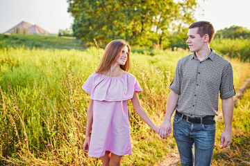 Fototapeta premium Shot of a young couple holding hands and running through the park.