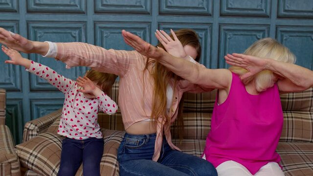 Young woman doing dab gesture internet meme with senior old grandmother and small kid child girl