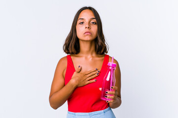 Young mixed race woman holding a milk shake isolated taking an oath, putting hand on chest.