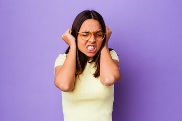 Young mixed race woman isolated covering ears with hands.