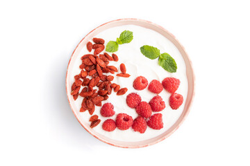 Yogurt with raspberry and goji berries in ceramic bowl isolated on white background. top view.