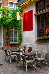 Fototapeta na wymiar Old street with table of cafe in historic city center of Antwerpen (Antwerp), Belgium. Cozy cityscape of Antwerp. Architecture and landmark of Antwerpen