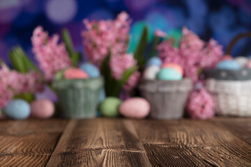 Easter background.  Easter eggs and spring flowers. Rustic wooden table. Pastel colors bokeh. Place for typography.