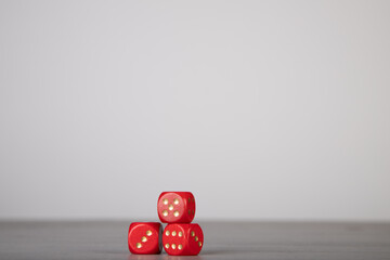 the die is cast, red dice falling on a gray wooden board
