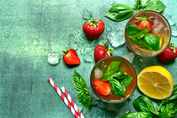 Cold summer fruit lemonade with strawberry, lemon and basil. Top view with copy space.