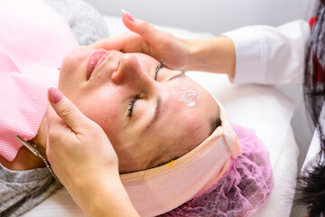Facial massage at the beautician at the reception, visiting a beauty salon, a sense of relaxation.