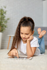 Naklejka premium little child girl using digital tablet