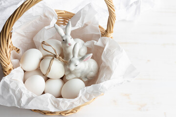 Easter bunny figurines with eggs in basket close up