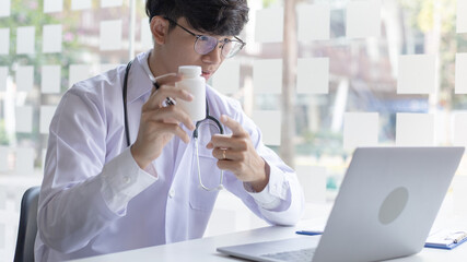 Close-up of a man with glasses using a laptop, Doctor is talking and giving advice on drug use with patients through laptops to prevent the spread of the virus, Record a video, Making video call.