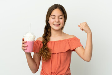 Little caucasian girl with strawberry milkshake isolated on white background doing strong gesture