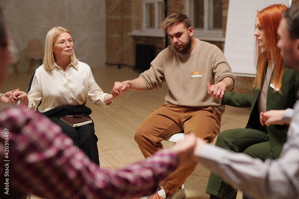 Poster patients of mental support group and counsellor holding by hands while listening to one another