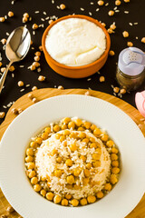 Traditional Turkish Rice Cooked With Chickpea on black background with yoghurt.