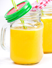 Orange juice and green leaves isolated on a white background.A glass of orange juice and drinking straw. Healthy food.