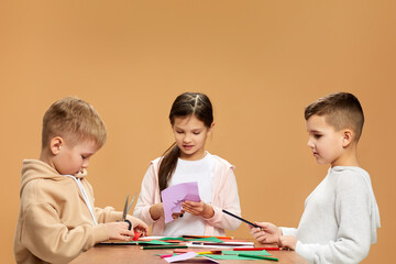 happy children cutting colored papers with scissors