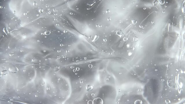 Motion, rotation of the liquid cream gel transparent cosmetic texture with bubbles. Organic cosmetics, medicine. Top view. Slow motion. High quality 4k footage