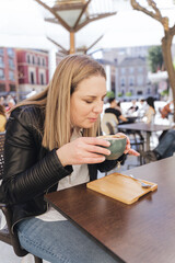 Young woman drinking coffee on a sunny terrace. Healthy and relaxing life