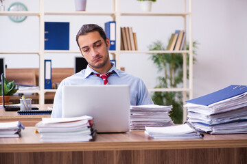 Obraz premium Young male employee unhappy with excessive work