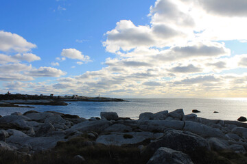 Fototapeta na wymiar Looking along the rocky coastline toward Peggy's Cove, Nova Scotia, and the Peggy's Cove lighthouse.