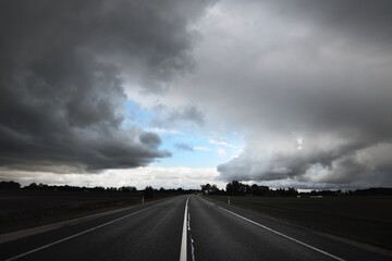Empty highway (asphalt road) through the fields. Dramatic sky before the rain and thunderstorm....