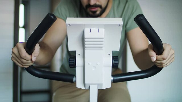 Fitness man on bicycle doing spinning at gym
