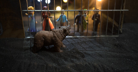 People and animals on opposite sides of the fence concept. Creative decoration with toy figures. Burning colorful background.