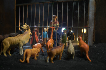 People and animals on opposite sides of the fence concept. Creative decoration with toy figures....