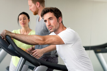 Fototapeta na wymiar Group of friends exercising on treadmill machine