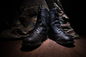 War concept. Old military shoe in a dark toned foggy background. Creative concept of conflict...