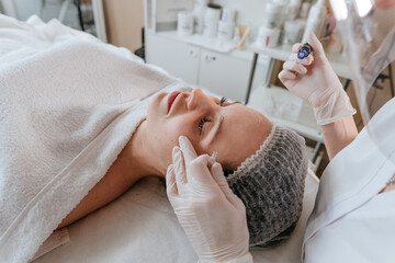 Obraz na płótnie Canvas Close-up of an esthetician making facial cleansing procedure