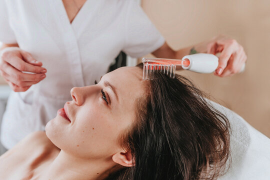 Close-up of an esthetician making cosmetologic procedure with hair and head skin