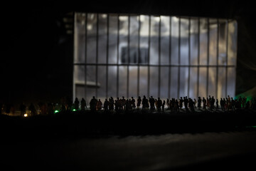 People and police government power concept. Crowd looking on big handcuffs at night with fog and backlight. Creative artwork decoration. Selective focus.