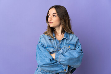 Young Romanian woman isolated on purple background keeping the arms crossed