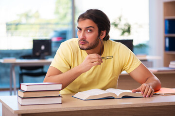 Young male student preparing for exams in the classroom