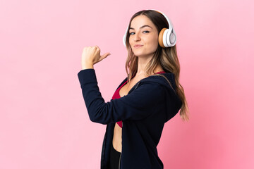 Young Romanian sport woman isolated on pink background proud and self-satisfied